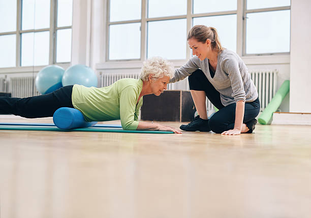 istock Physical therapist helping elderly woman in her workout 527464113