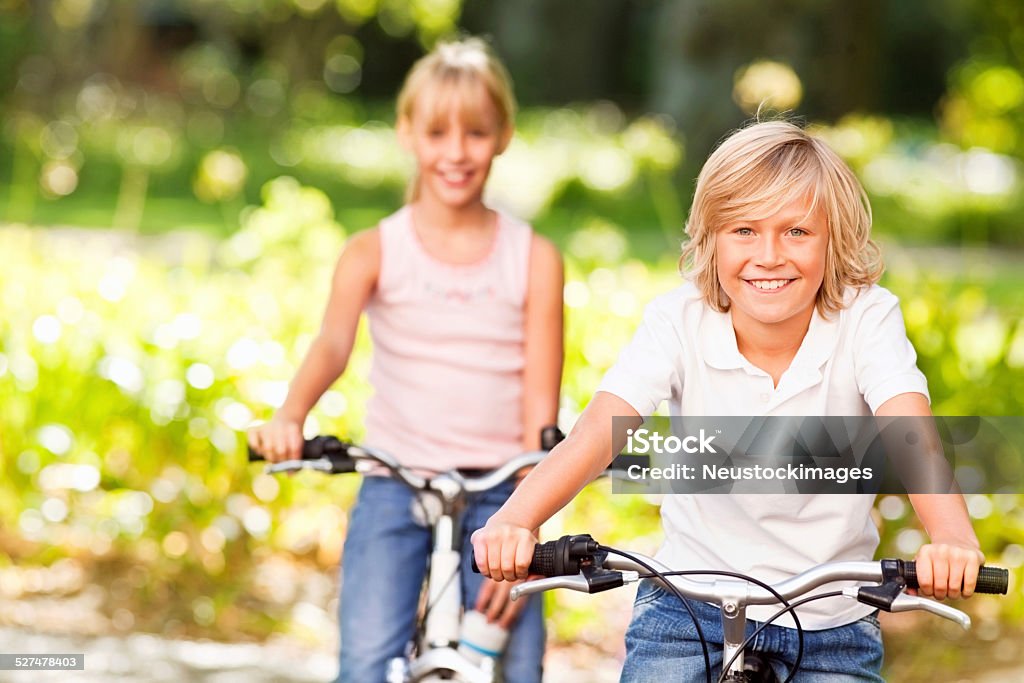 Glücklich junge Fahrradfahren mit Schwester hinten im park - Lizenzfrei Kind Stock-Foto