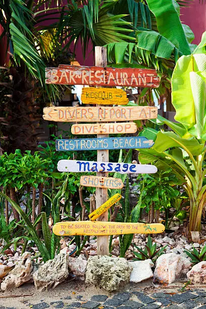 Signpost made of flotsam at tropical resort showing directions to facilities at beach