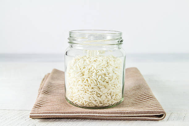 istock Rice grain in glass bottles on brown cloth 527483029