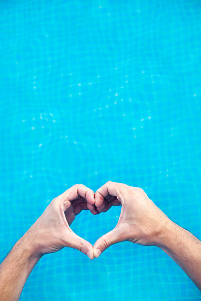 istock Hands in heart shape over a swimming pool. 527483973