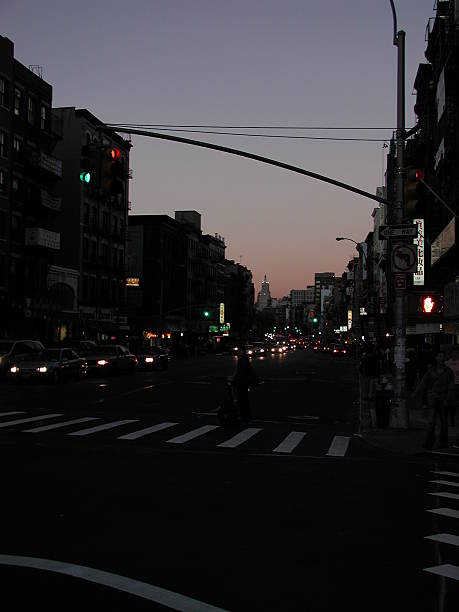 New York City, NY, USA - October 13, 2003: Looking Up Canal street. On the street, people are on the move to get home. Young woman on traffic, waiting for light to change. In Manhattan Chinatown.