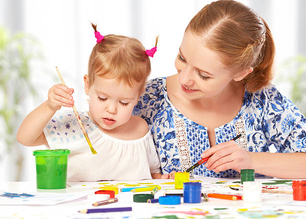 istock mother and child  daughter draw paints 527495057