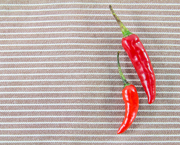 istock Close up two fresh chili peppers on a napkin 527497265