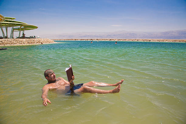 istock Man floating and reads a book at the Dead Sea 527511117