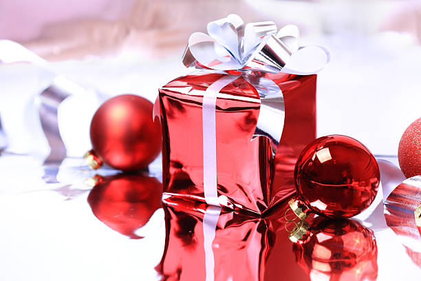 istock Colorful red gift with Christmas balls on silver background 527511133