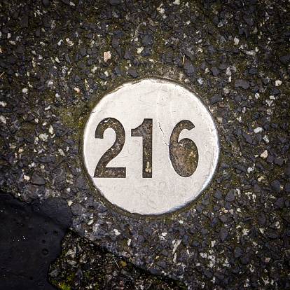 house number two hundred and sixteen, cut out in a metal plate