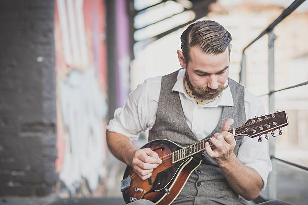 istock handsome big moustache hipster man playing mandolin 527511849