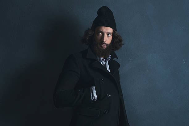 istock Retro man with beard wearing black coat and woolen cap. 527521978