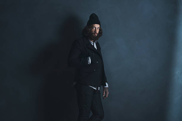 istock Retro man with beard wearing black coat and woolen cap. 527522112