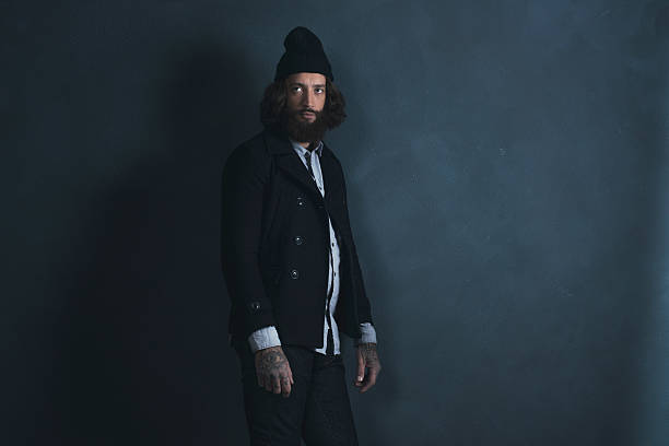 istock Retro man with beard wearing black coat and woolen cap. 527522198