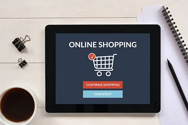 Photo of Online shopping concept on tablet screen with office objects