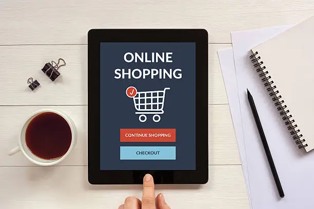 Photo of Online shopping concept on tablet screen with office objects