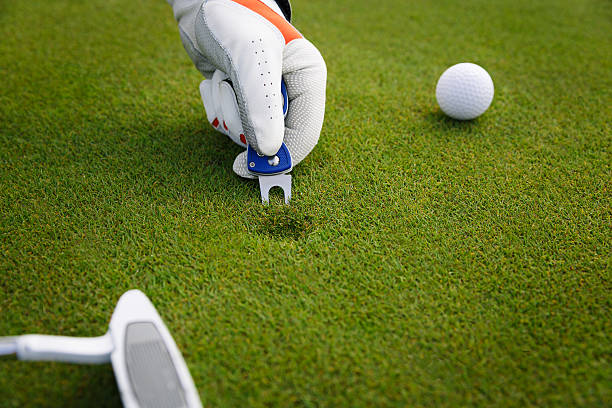 Marking golf ball position at the green. Focus on marker. stock photo