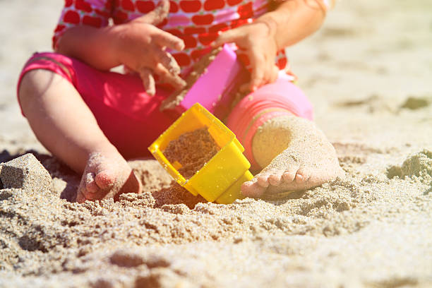 fillette jouent avec des jouets de plage - sandbox child human hand sand photos et images de collection