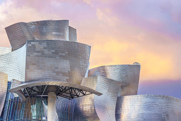 The curved shapes of the Guggenheim Bilbao, Spain - May 1, 2016: The Guggenheim Museum is located in Bilbao, Spain. It is a mettalic modern and futuristic building, full of details and curved shapes. frank gehry building stock pictures, royalty-free photos & images