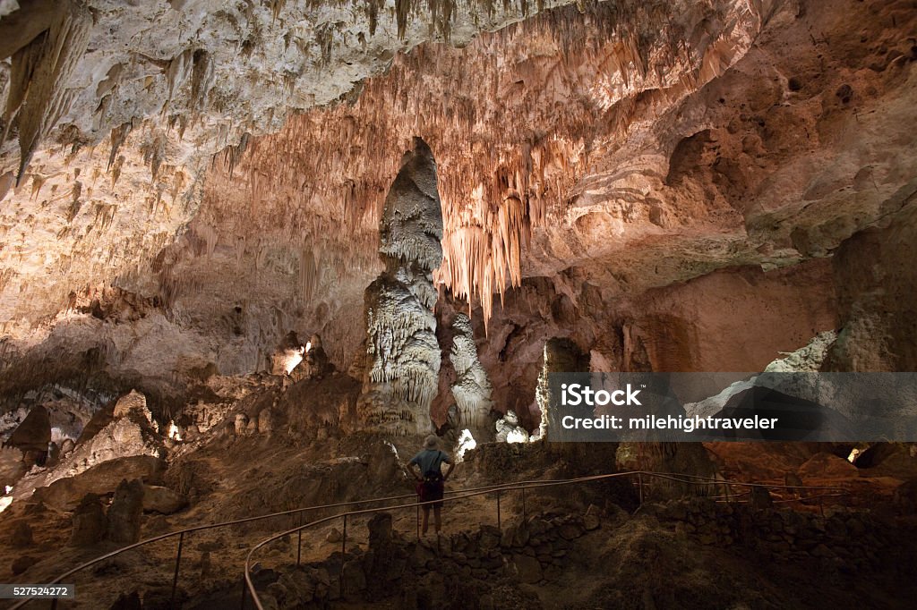 Visitor hikes Carlsbad Caverns Big Room Giant Chandelier New Mexico In the middle of the Big Room, a visitor looks up at the Giant Chandelier made of ribbon stalactites and stands in front of huge stalagmites in Carlsbad Caverns National Park located in the Guadalupe Mountains, New Mexico. Carlsbad Caverns National Park Stock Photo