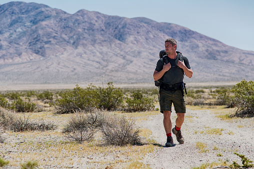 One man backpacking across the Mojave Desert.  This image shot on location at the Trona Pinnacles National Landmark near Ridgecrest, California.  