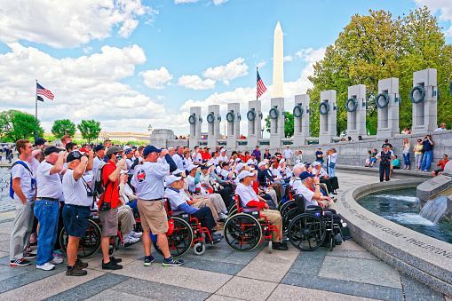Washington DC, USA - May 2, 2015: Tourists and group photo of War Veterans, members of Honor Flight Central Florida nonprofit organization, at Pillars on National World War 2 Memorial, National Mall
