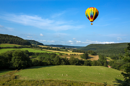 A hot air balloon flying over the countryside of the Yorkshire Dales in the north of England.