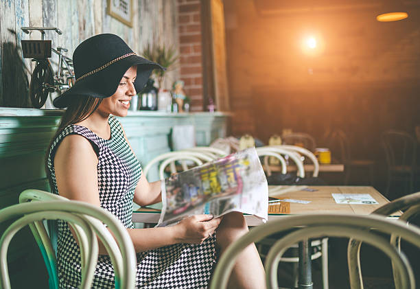 istock pretty woman reading newspaper 527531264