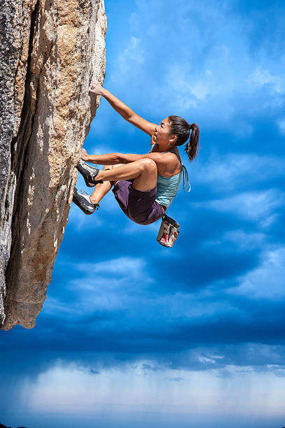 Rock climber clinging to a cliff. stock photo