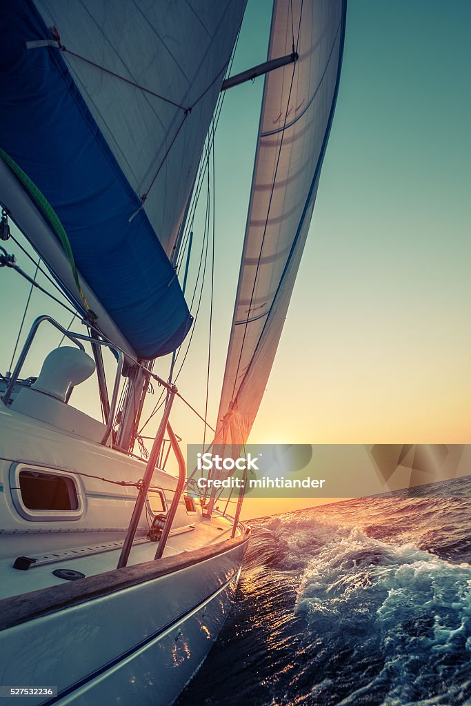 Sail boat Sail boat moving in the open sea at sunset Sailboat Stock Photo