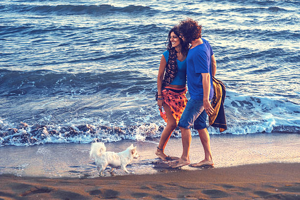 istock Yong couple on beach playing with little dog 527532480