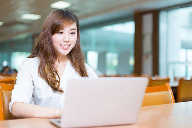 istock young beautiful asian girl student with laptop in library 527534482