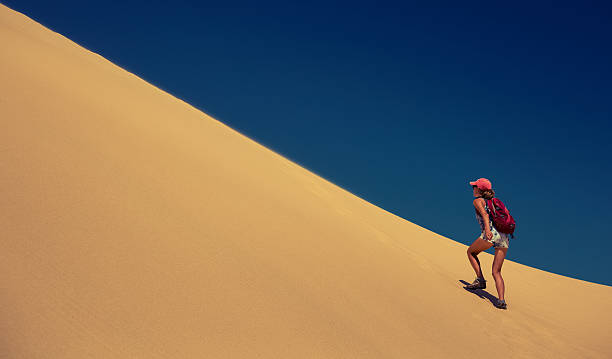 Hiker in the desert Hiker climbing the dune in the desert mui ne bay photos stock pictures, royalty-free photos & images