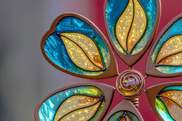 Close up of a stained glass flower lawn ornament with blurred background