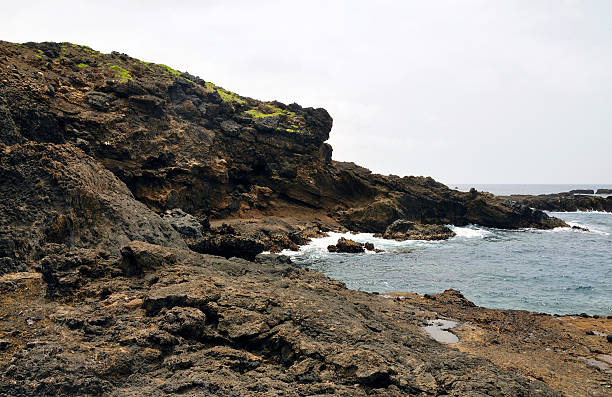 istock Waves crash against the rugged volcanic coastline 527542278