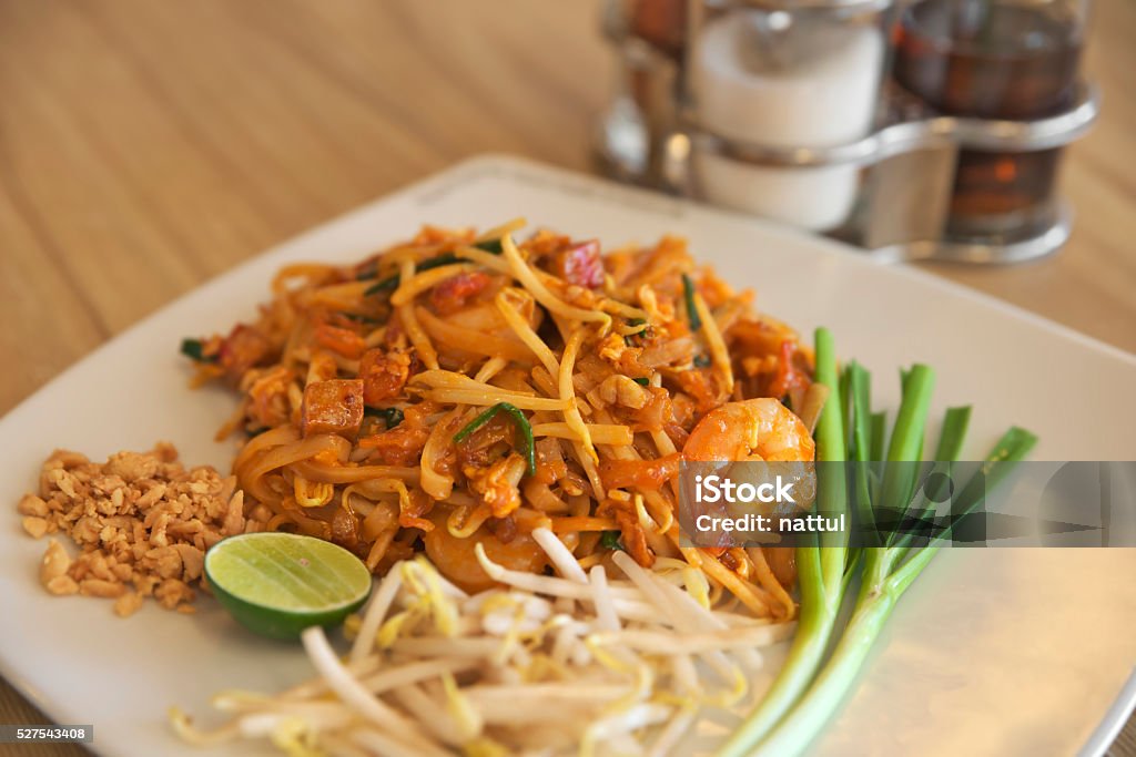 Shallow DOF of PadThai Shallow DOF of PadThai focused on Shrimp with flavoring container in background Banana Flower Stock Photo