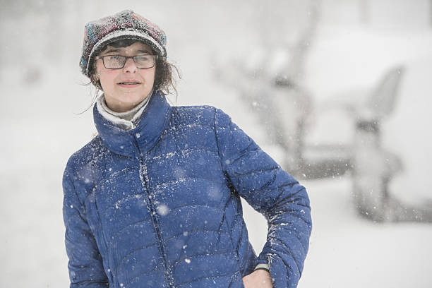 teenager-mädchen unter schneefall auf der straße - queens head stock-fotos und bilder