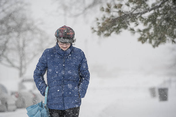 teenager-mädchen unter schneefall auf der straße - queens head stock-fotos und bilder