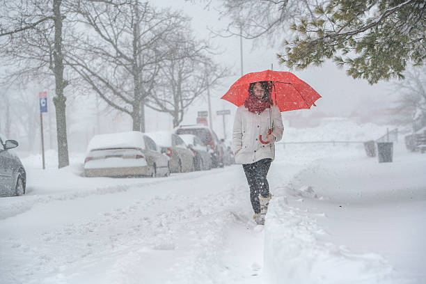 teenager-mädchen mit regenschirm unter schneefall auf der straße - queens head stock-fotos und bilder