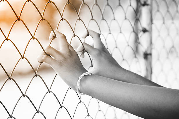 istock hand in jail. Black and white. 527544278