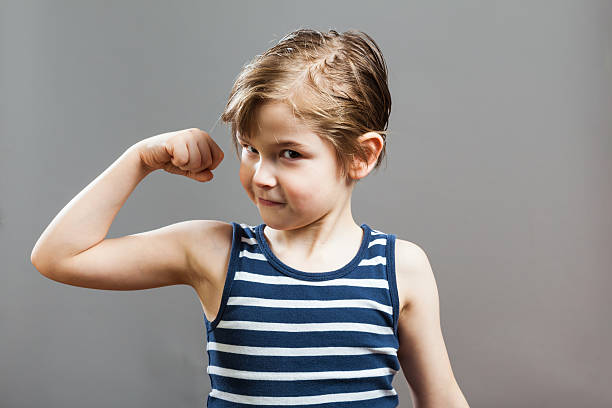 sportive solide petit garçon, montrant ses muscles - child human muscle flexing muscles little boys photos et images de collection