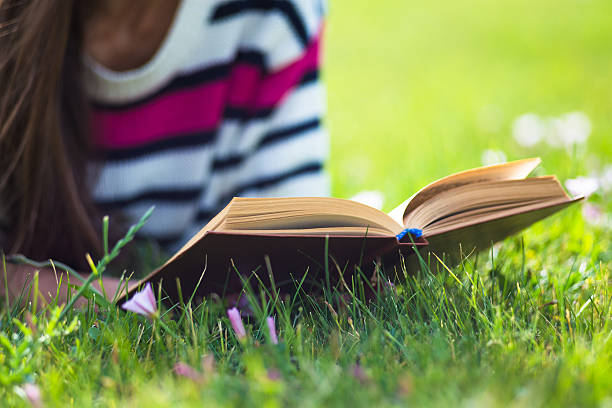 istock Young girl relax with book in summer park 527551484