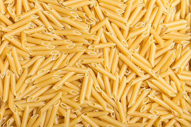 Macaroni background Raw penne rigate texture. comida italiana stock pictures, royalty-free photos & images