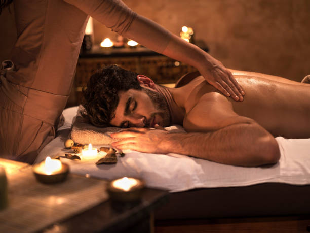 Young man enjoying with eyes closed during back massage. Relaxed man receiving back massage at the spa and enjoying with his eyes closed. man massage stock pictures, royalty-free photos & images