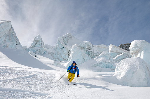 Freerider mountain guide skiing in the Schwartztor Glacier between seracs, Zermatt, Swiss, Europe. Horizontal frame, copy space