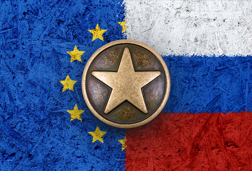 Bronze star symbol on the flags of EU and Russia in background