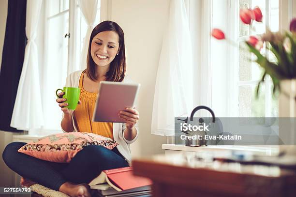 Smiling Woman Reading Her Tablet At Home Stock Photo - Download Image Now - Springtime, One Woman Only, Women