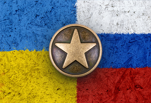 Bronze star symbol on the flags of Ukraine and Russia in background