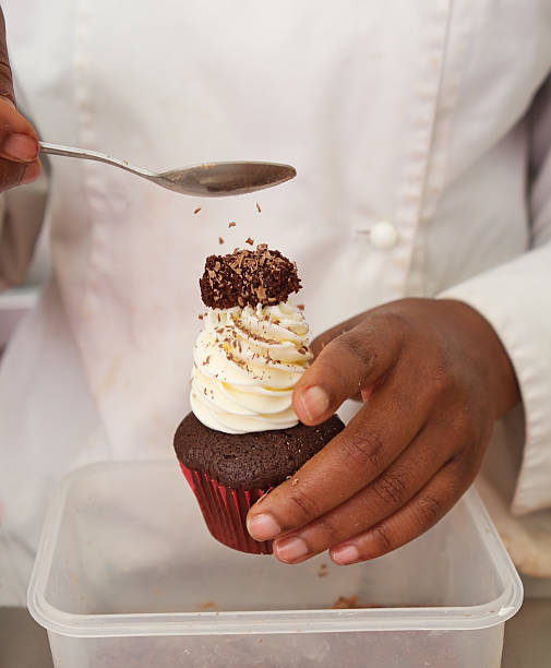 istock Sprinkles being applied to chocolate cupcake 527556235