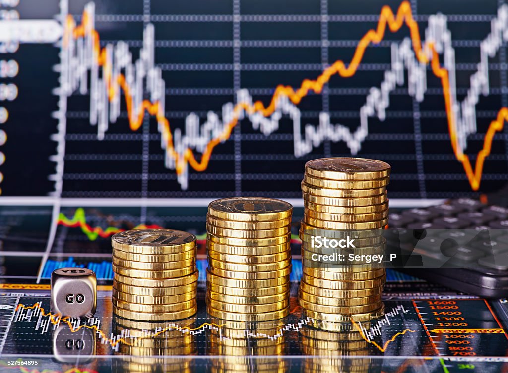 Uptrend stacks coins, dices cube  GO and calculator Uptrend stacks coins, dices cube with the word GO and calculator on the financial stock charts as background. Selective focus Analyzing Stock Photo