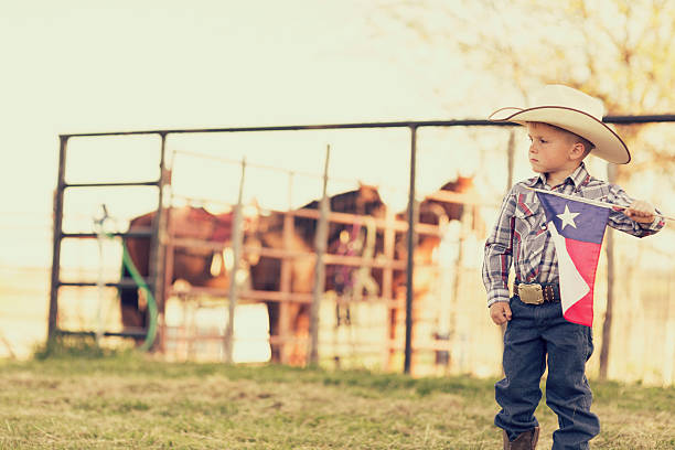 Texas Cowboy A young child cowboy is proud to display the flag of Texas. texas cowboy stock pictures, royalty-free photos & images