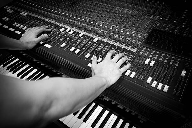 istock sound engineer hands on studio mixer & electric piano, synthesizer 527565601