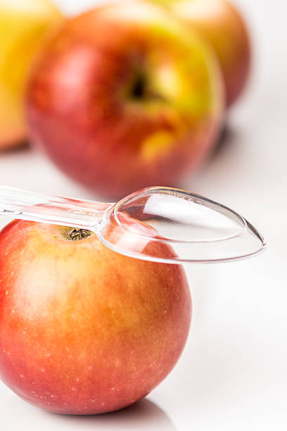 istock red apple and translucent medicine spoon on the table 527567081
